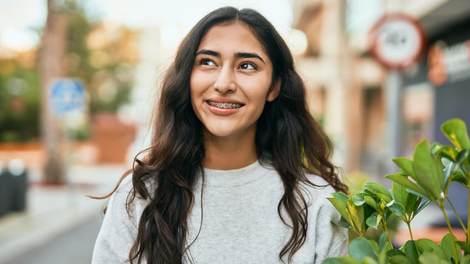 smiling girl with traditional metal braces 